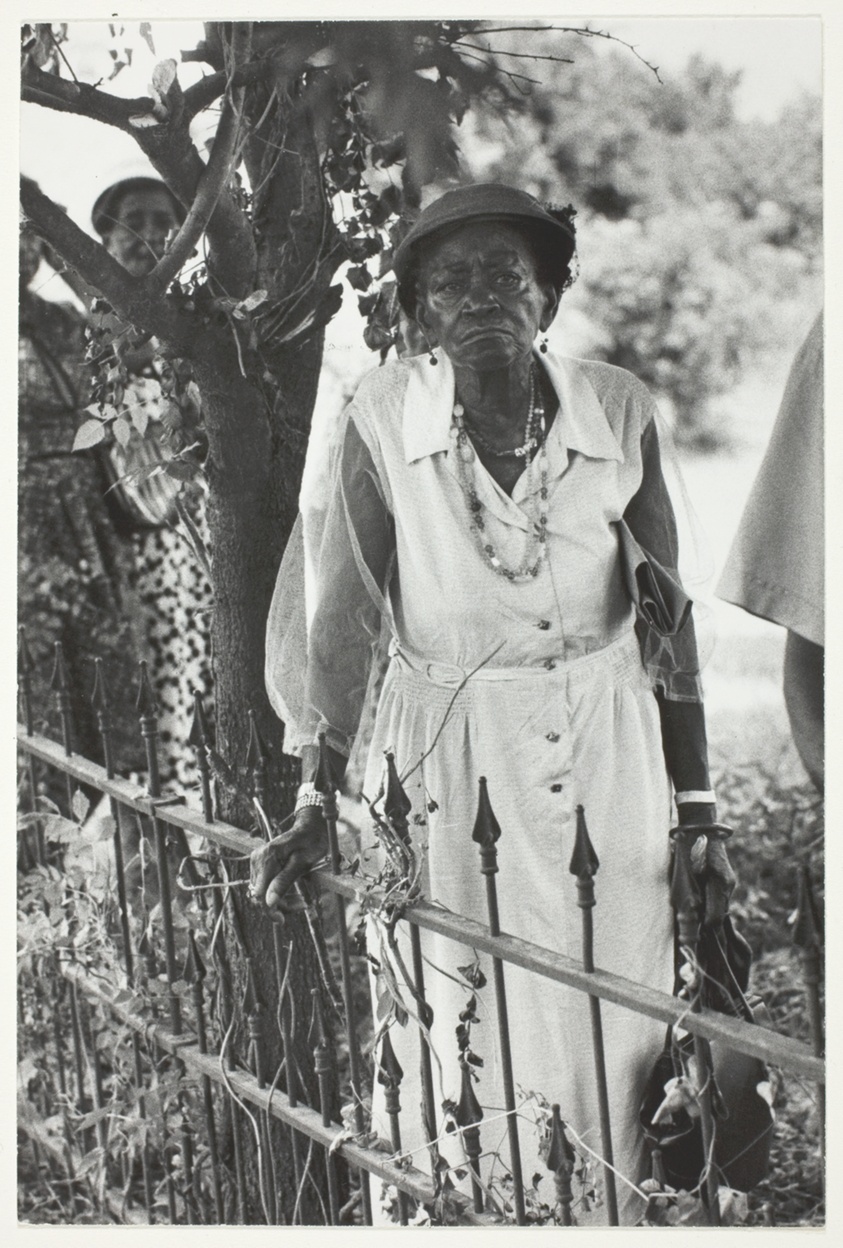 Old Negro Woman Standing by Iron Fence