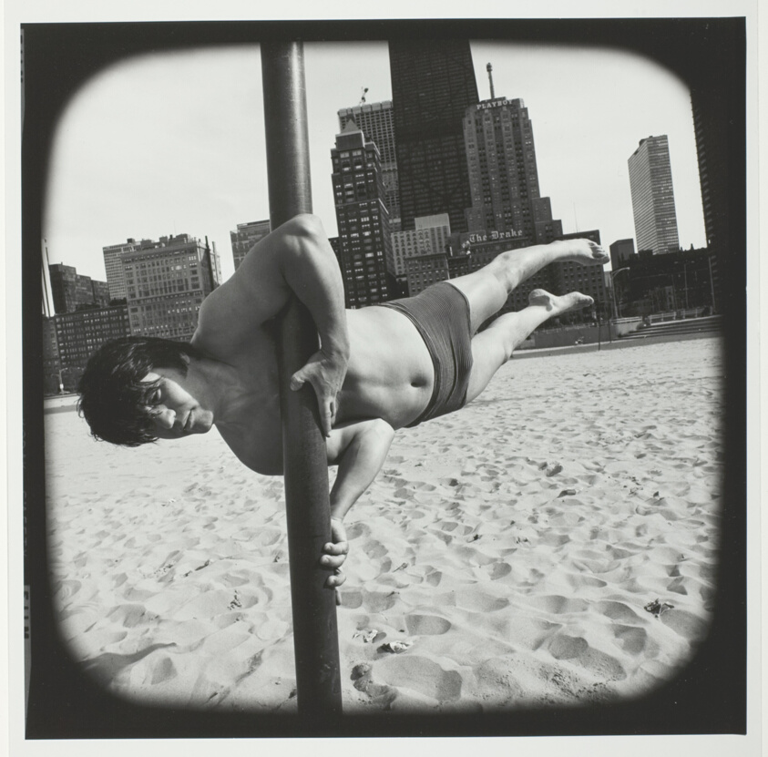 Untitled (Man in Bathing Suit Balancing Himself on Pole Vertical to the Sand), from the series "Beach"