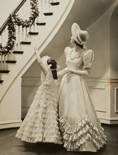 Little Girl and Woman in Formal Gowns, Looking up Staircase
