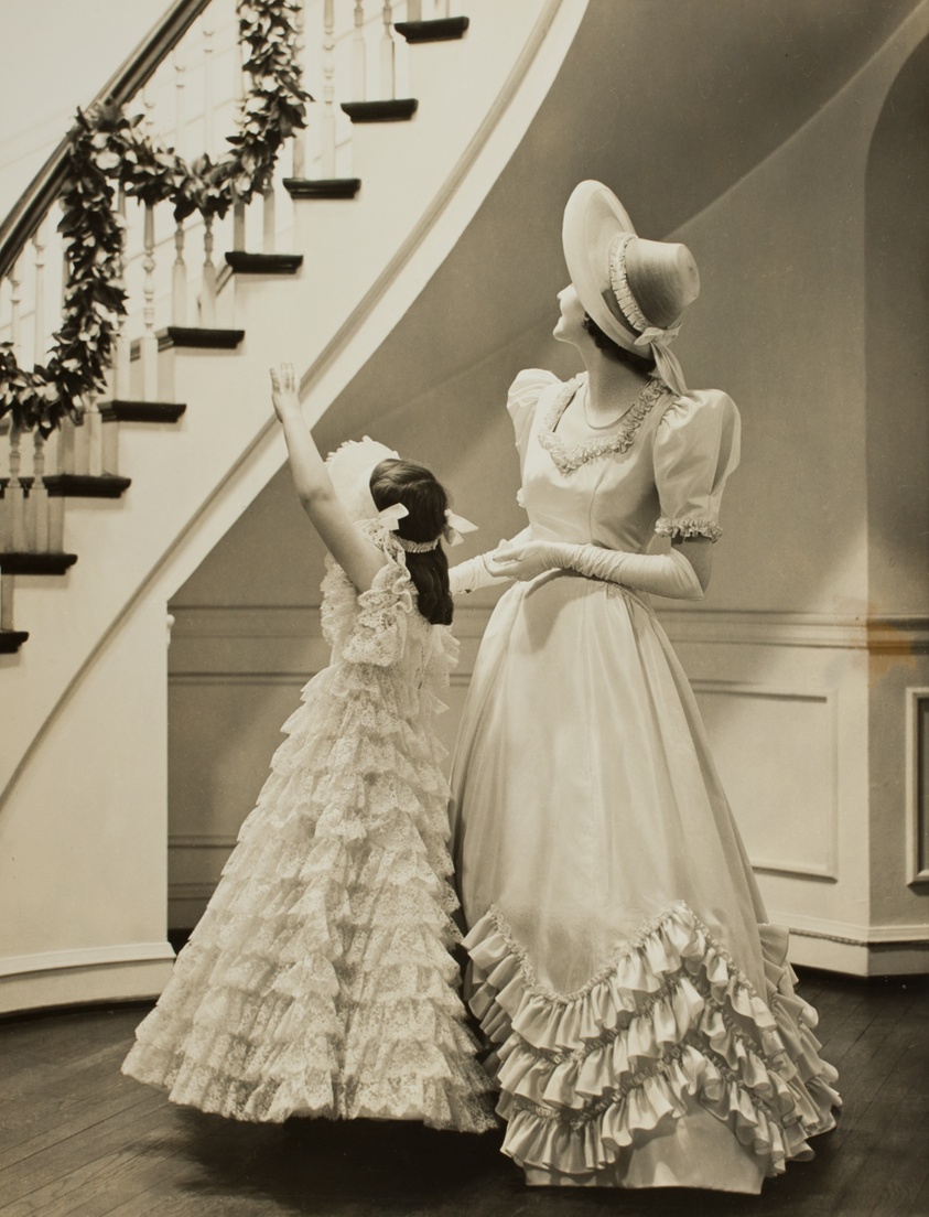 Little Girl and Woman in Formal Gowns, Looking up Staircase