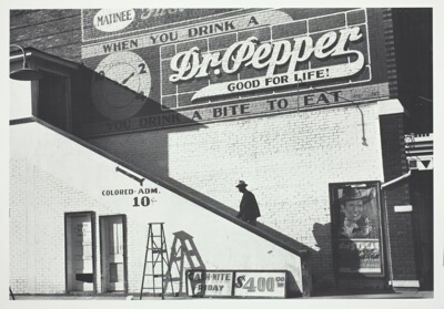 Negro man entering a movie theatre by outside stairway "For Colored Only" in the Delta area, Belzoni, Mississippi