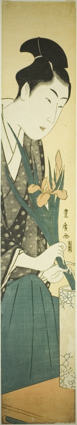 Young man arranging irises in a vase