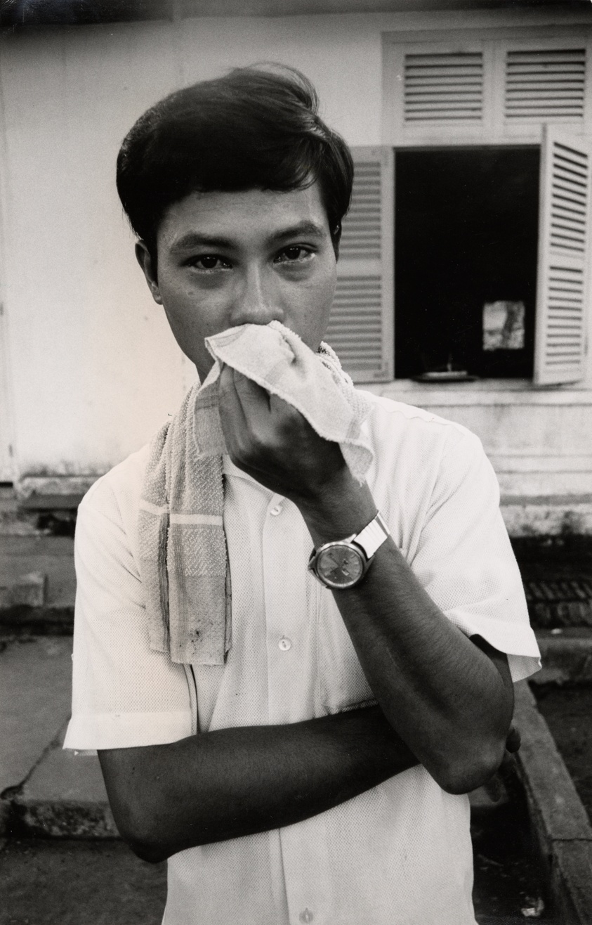 Vietnam peace fact-finding mission: one of the peace marchers, a Vietnamese student, wipes teargas from his eyes after the peace march has been broken up by the Saigon police