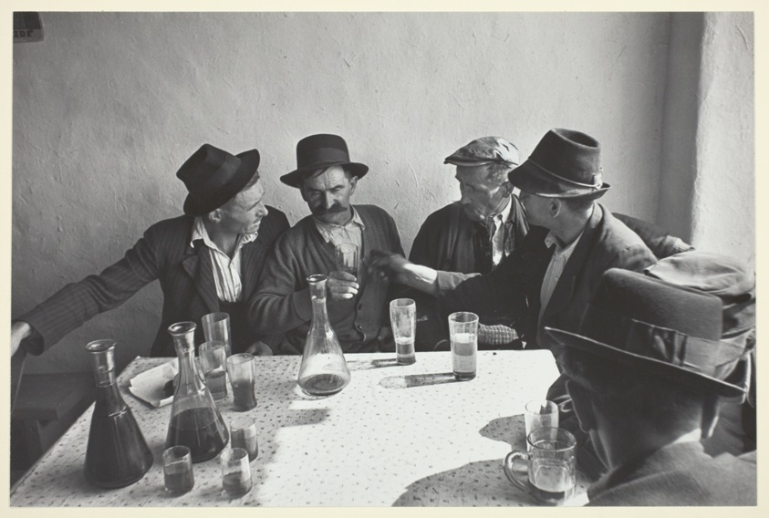Men Seated Around a Table Drinking Wine