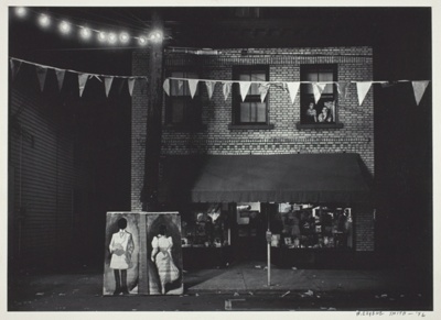 Untitled [night view, store front with pennants]